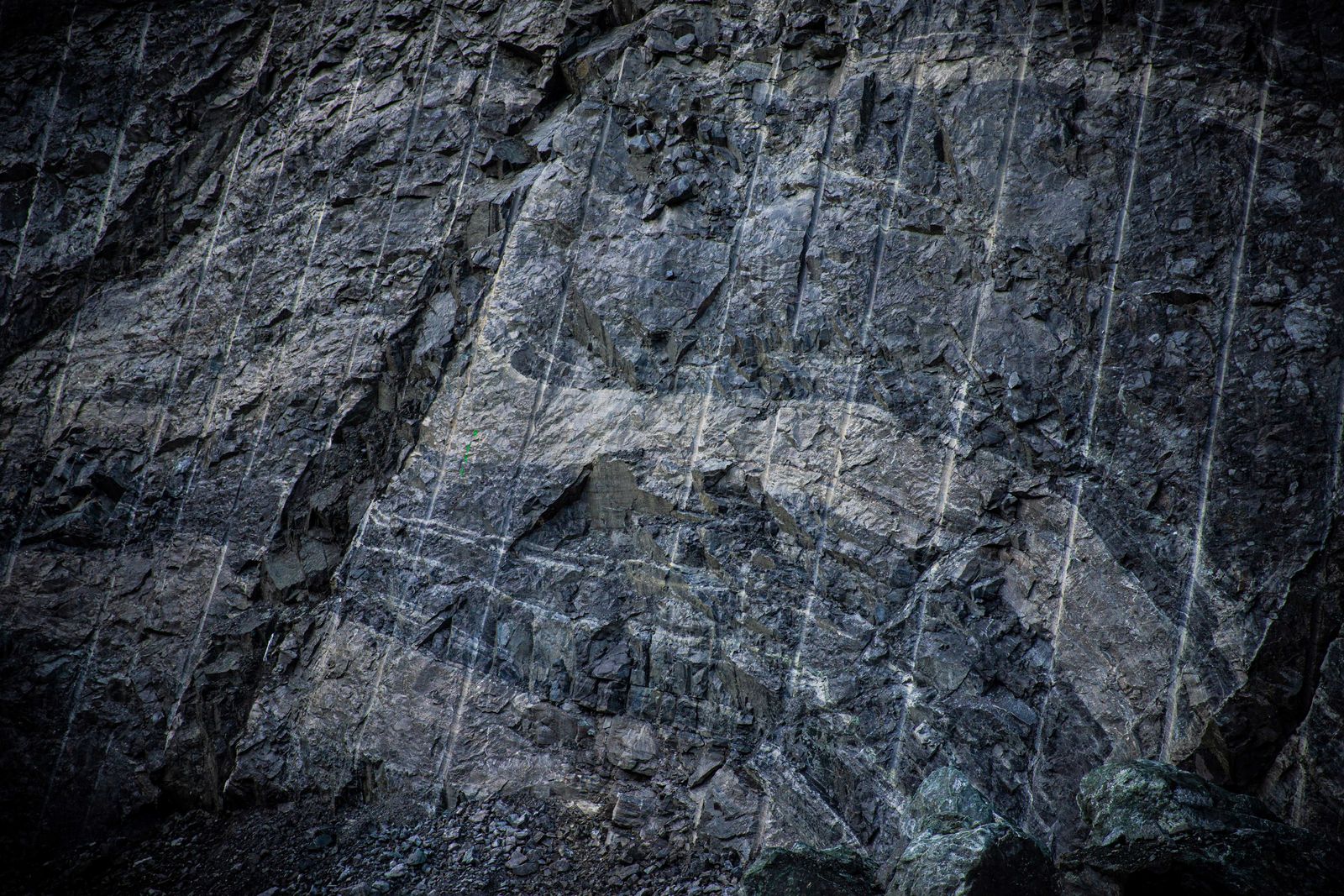 A rock wall in the mine with clear traces of drilling and loosening of ore.